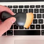 Brush being used to clean a computer keyboard
